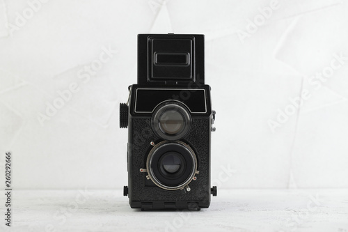 The old medium format film TLR camera, camera for modern lomography on white cement background. photo