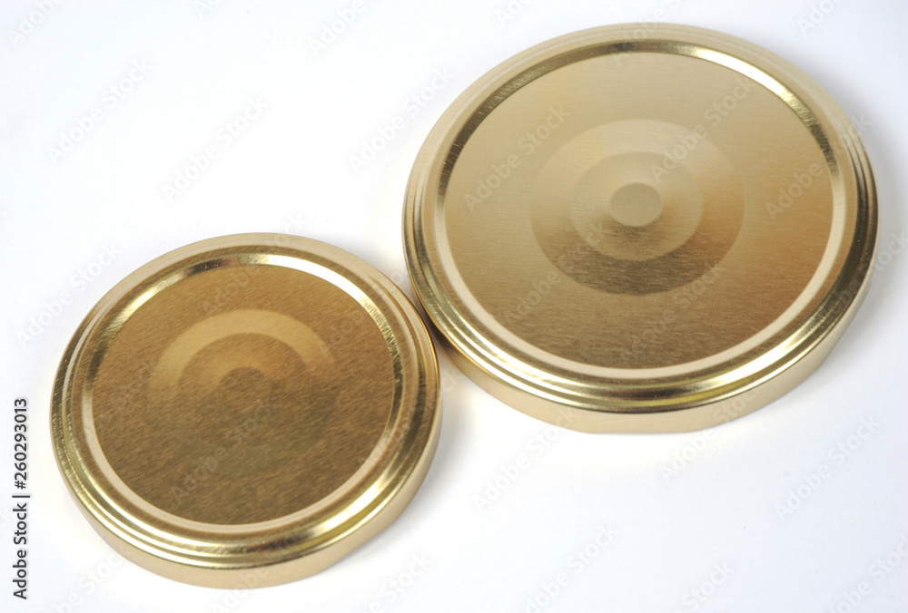 Screw caps for glass jars. For canning, canned food. Golden caps on white background Screw caps for glass jars. For canning, canned food. Golden caps on white background