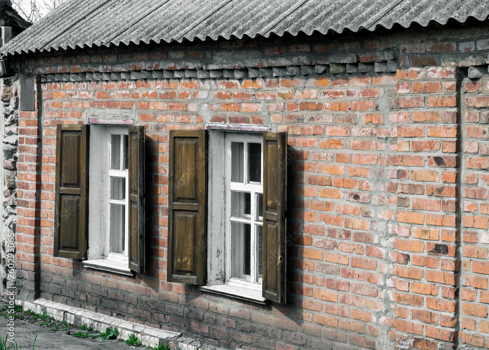 Windows with wooden shutters in a rustic brick house Windows with wooden shutters in a rustic brick house