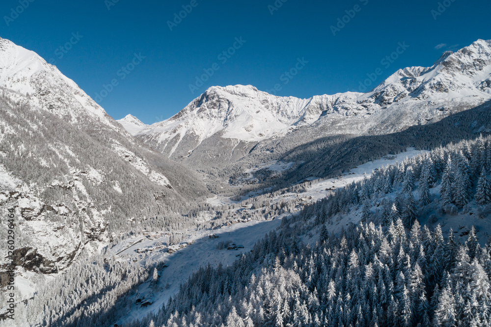 Mountain valley in winter season. Panoramic view over the forest. 