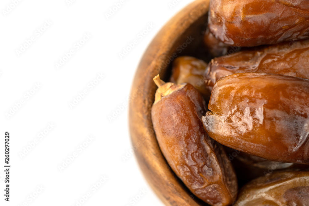 Naklejka premium Dried of sweet dates palm fruits on wooden bowl on white background. Dates is a dried fruit that provides high energy.