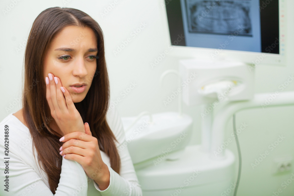 Young female having toothache. Upset woman at the dentist. Constant pulsating pain Young female having toothache. Upset woman at the dentist. Constant pulsating pain