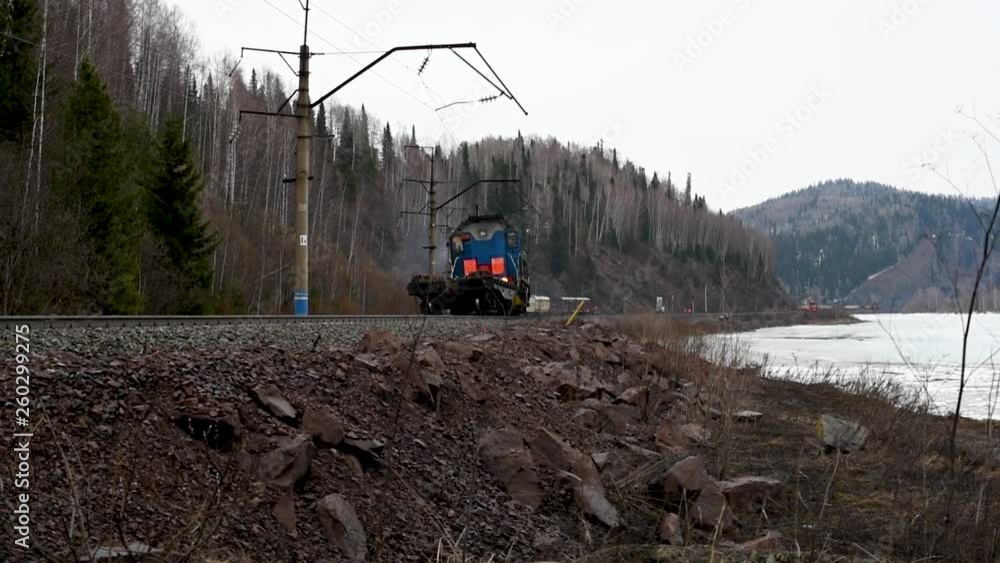 Electric train moves on rails in the spring outdoors Blue train moving ...