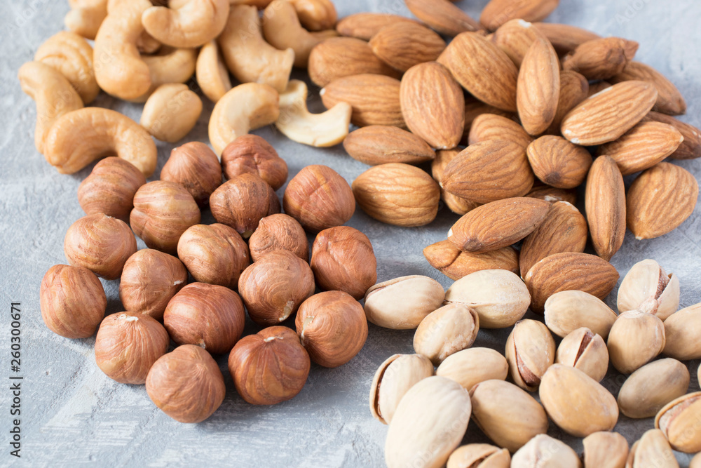 mixed nuts on a gray background. Walnut, pistachios, almonds, hazelnuts and cashews, walnut. mixed nuts on a gray background. Walnut, pistachios, almonds, hazelnuts and cashews, walnut.