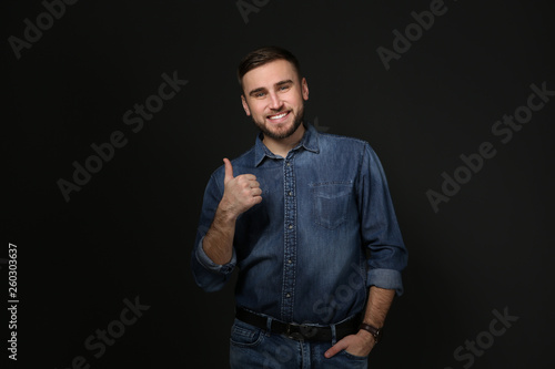 Man showing THUMB UP gesture in sign language on black background