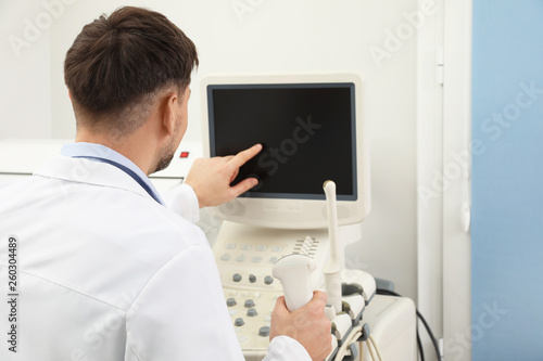 Professional sonographer using modern ultrasound machine in clinic