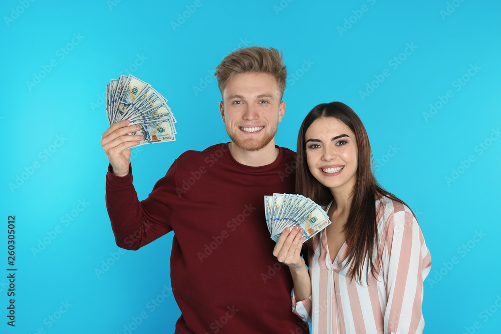 Young couple with money on color background Young couple with money on color background