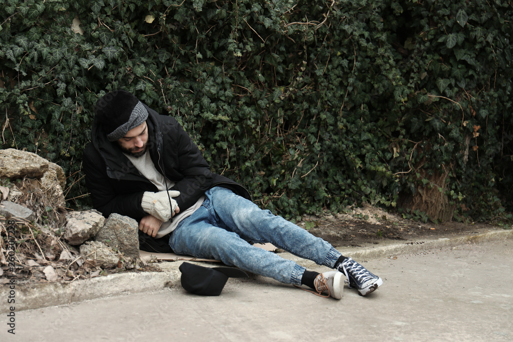 Poor homeless man lying on street in city Stock Photo | Adobe Stock