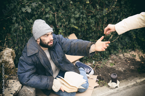 Slika na platnu Woman giving alms to poor homeless man on street