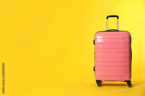 Fotografija Stylish suitcase on color background. Space for text