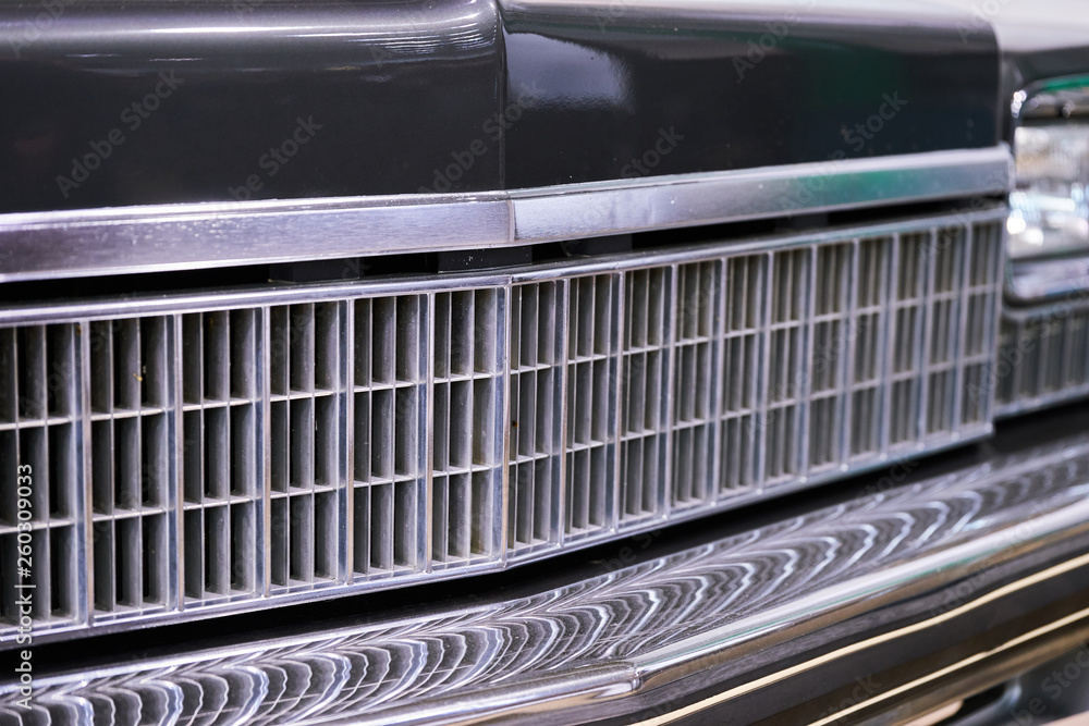 Vintage American car. Close-up of headlights and grille
