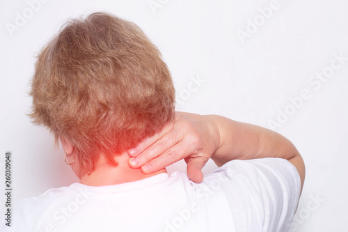 Elderly woman holding her neck behind the concept of pain in the neck and inflammation due to problems with the spine and intervertebral hernia, osteochondrosis, copy space, fibromyalgia