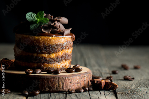 Chocolate cakes on black slatter board with mint, coffee beans on dark background, closeup photo. Fresh, tasty dessert food concept.  photo