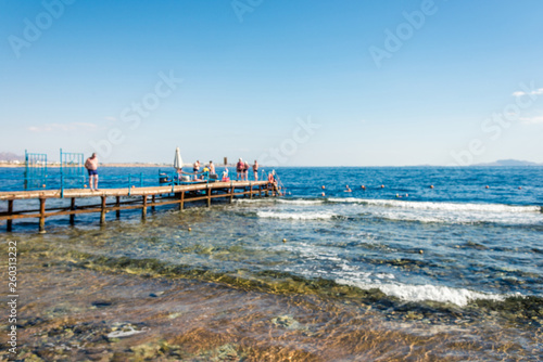 travel and vacation, sea, pier with people in defocus.
