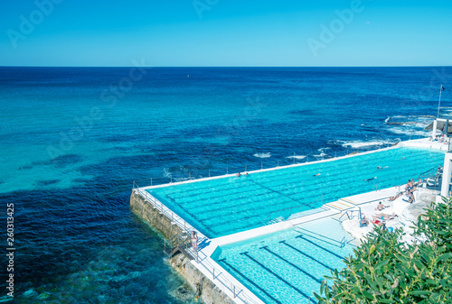 Swimmers enjoy beautiful pool along the sea