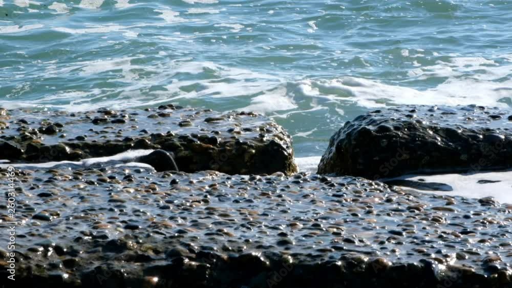 Slow motion shooting motion of sea waves. A spray of water. The blue surface of the sea. Daylight. Warm weather.