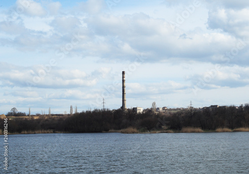 Smoke industrial chimney near the lake