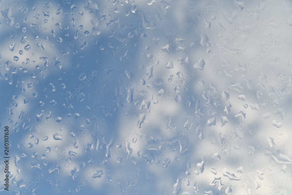 Fototapeta premium krople wody na szybie na tle chmur