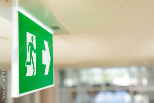 Selective green fire exit sign on ceiling.Fire fighting equipment concept photo