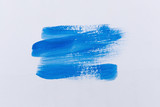 Blue painting and color tube on white paper background.