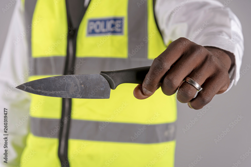 Salisbury, Wiltshire, UK. April 2019. Police officer holding a siezed kitchen knife Salisbury, Wiltshire, UK. April 2019. Police officer holding a siezed kitchen knife