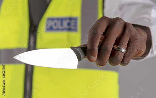 Salisbury, Wiltshire, UK. April 2019. Police officer holding a siezed kitchen knife photo