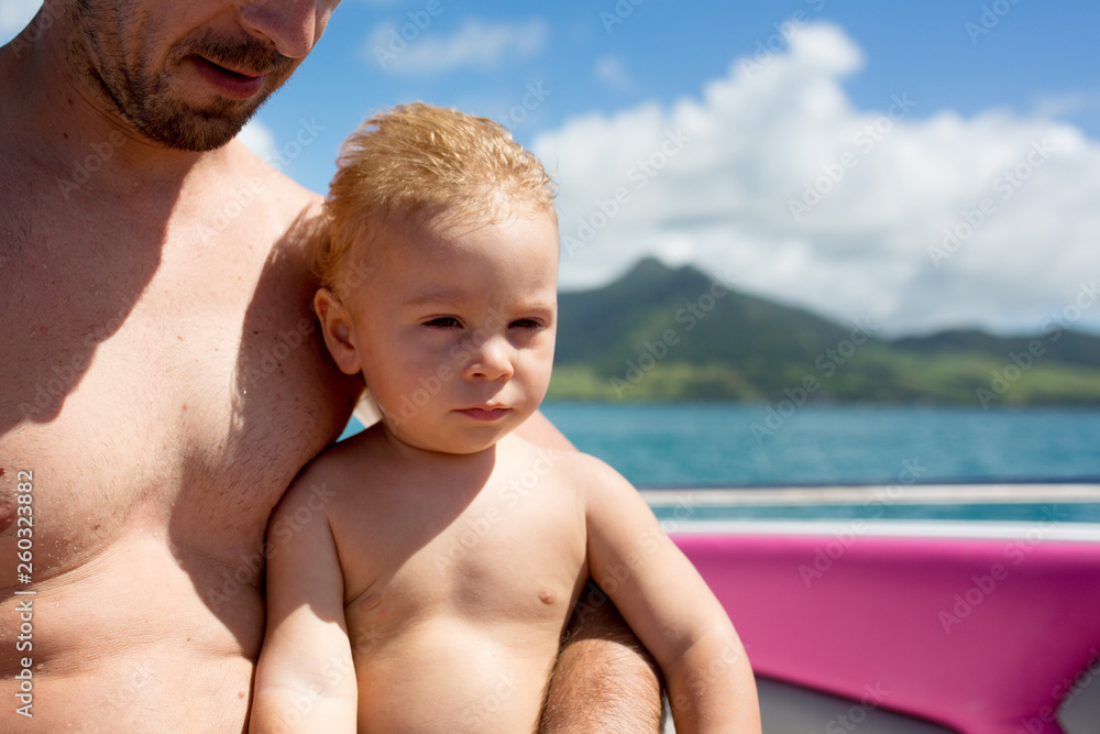 Happy beautiful fashion family, children and parents, dressed in hawaiian shirts, enjoying day trip with speed boat