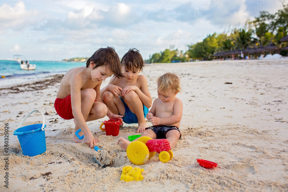 Fototapeta premium Cute baby boy playing with beach toys on tropical beach