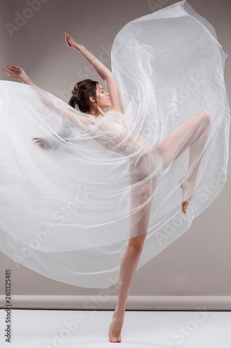 Beautiful ballet-dancer, modern style dancer posing on studio background