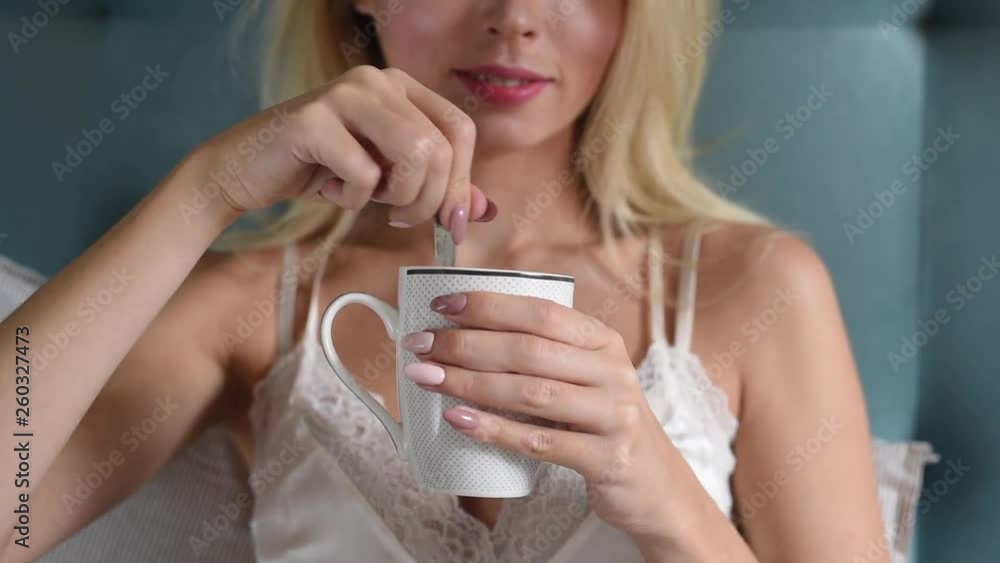 Young woman drinking morning coffee and eating croissants in bed Young woman drinking morning coffee and eating croissants in bed