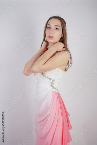 cute young teen girl stands in summer dress with pink Ombre on white background in Studio. 