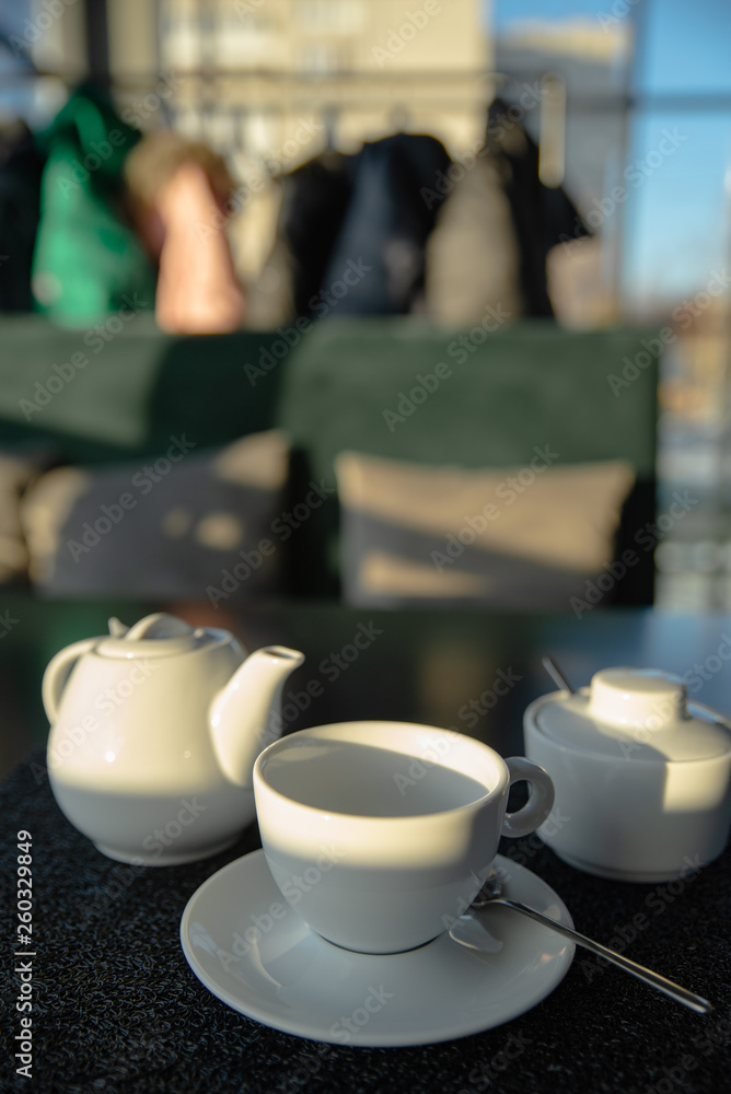 white cup with kettle on cafe table