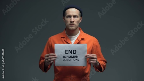 Prisoner holding End inhuman conditions sign in cell, human rights protection