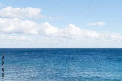 Clean, clear beautiful deep blue Atlantic Ocean backdrop wallpaper against a blue sky with few clouds and lots of copy space.  © Studio F.