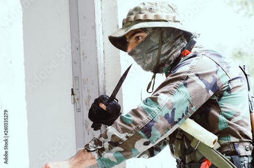 Special forces soldier holding handgun,prepares to gettin building silently photo