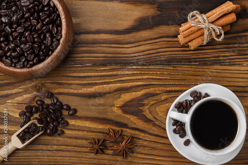Freshly hot brewed coffee. Coffee beans, cinnamon and anise stars on a dark wooden background