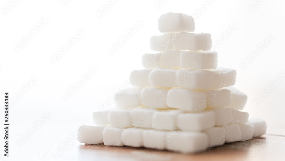 food, junk-food, cooking and unhealthy eating concept - close up of white lump sugar pyramid on wooden table food, junk-food, cooking and unhealthy eating concept - close up of white lump sugar pyramid on wooden table
