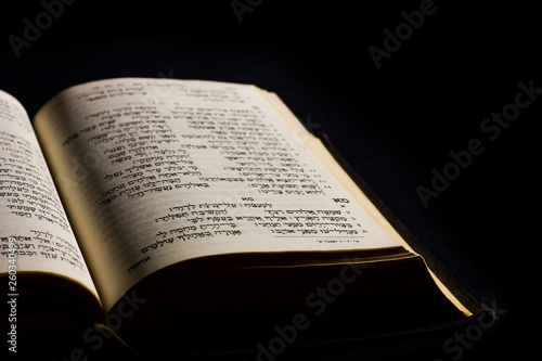 Obraz na plátně Open hebrew Bible, isolated on black background, with side lighting