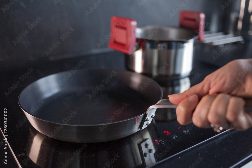 Frying pan on induction hob. Cooking healthy food at home. Frying pan on induction hob. Cooking healthy food at home.