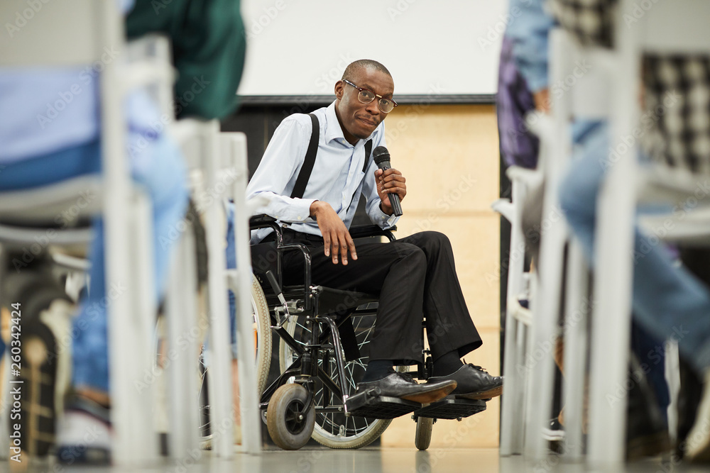 Content successful disabled mature black scientist in glasses sitting in  wheelchair and speaking into microphone while addressing conference Stock  Photo | Adobe Stock