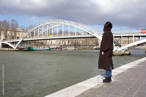 woman contemplating the river bridge in paris