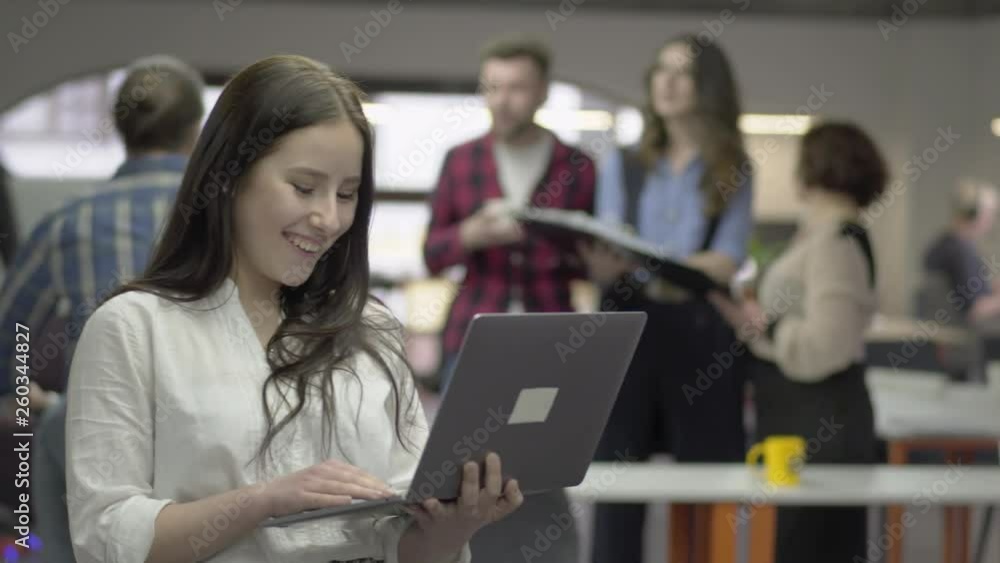 Portrait of the confident attractive woman working on her netbook in front of blurred figures of colleagues. Funny bearded man riding his bike, he comes closer and greets a girl, both smiling Portrait of the confident attractive woman working on her netbook in front of blurred figures of colleagues. Funny bearded man riding his bike, he comes closer and greets a girl, both smiling