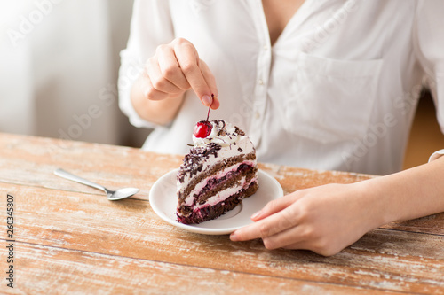 Tableau sur toile food, unhealthy eating and pastry concept - close up of woman taking cherry from