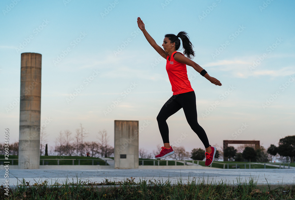 Young fit woman jumping while running. Fitness and healthy lifestyle
