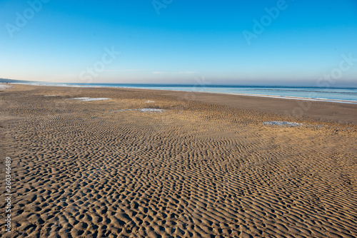 frozen sea beach in winter with low snow coverage