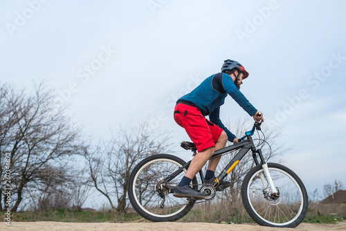Cyclist in red shorts and blue sweater rides a bicycle  active lifestyle.