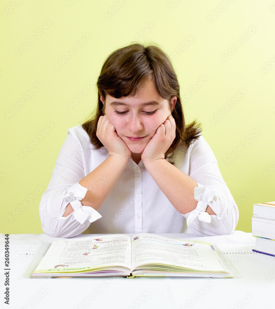 The girl reads the book carefully. Concept of school education The girl reads the book carefully. Concept of school education