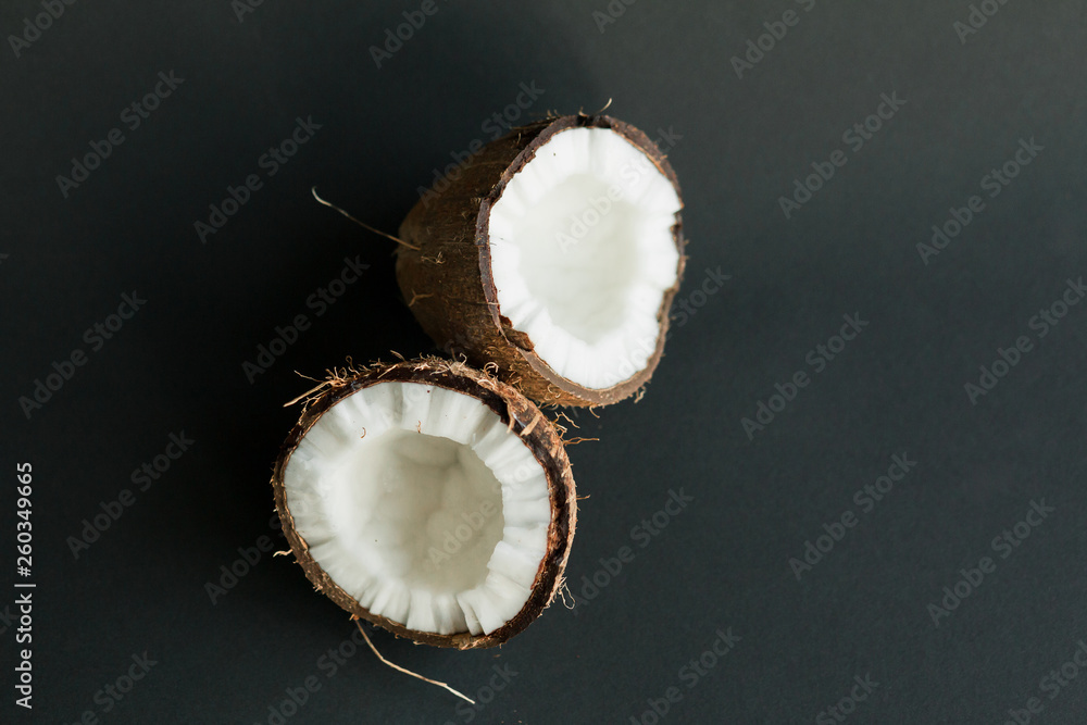 Broken ripe coconut on black background. White flesh