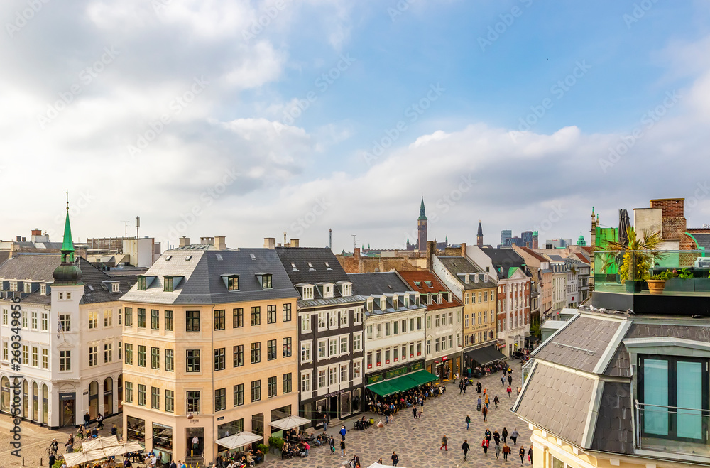 Copenhagen in the fall, people are walking around the square near the stork fountain, taking selfies sitting in restaurant, panoramic view of the city