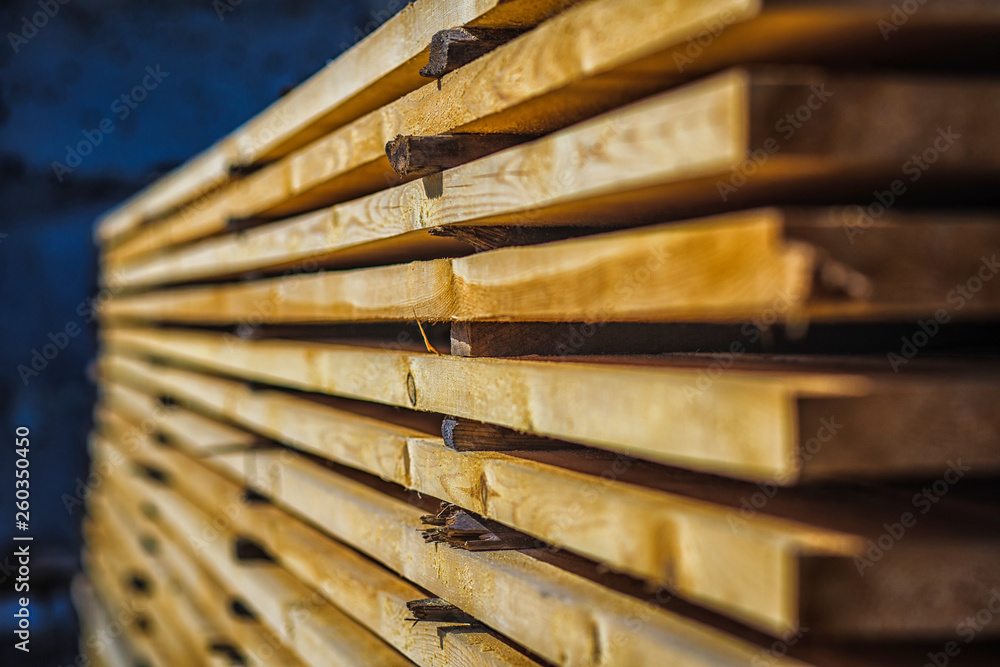 Wooden planks. Beams. Air-drying timber stack. Wood air drying (seasoning lumber or wood seasoning). Timber. Lumber. Close-up. Wooden planks. Beams. Air-drying timber stack. Wood air drying (seasoning lumber or wood seasoning). Timber. Lumber. Close-up.